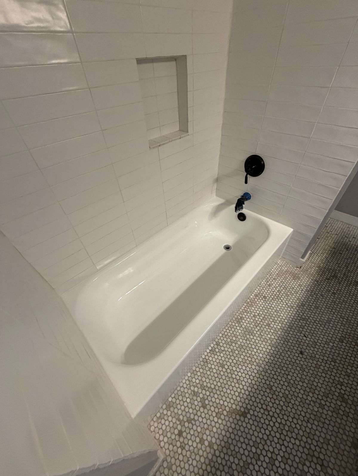 A cast-iron bathtub restored to a glossy white finish by reglazing